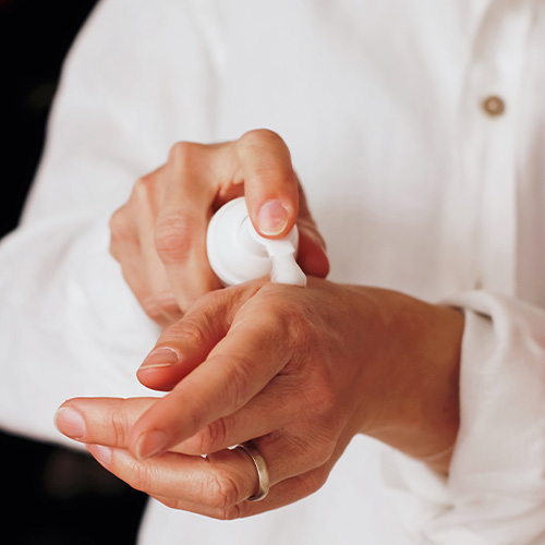 Cosmetica ingrediënten ABC Vrouw brengt cosmetica aan op haar hand